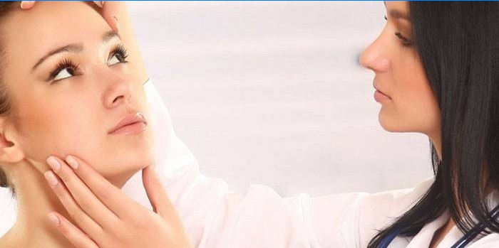 Kosmetolog undersöker en kvinnas ansikte innan Botox-injektioner.