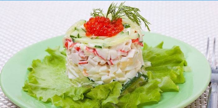 Del av Tsarskiy sallad med krabba pinnar och röd kaviar