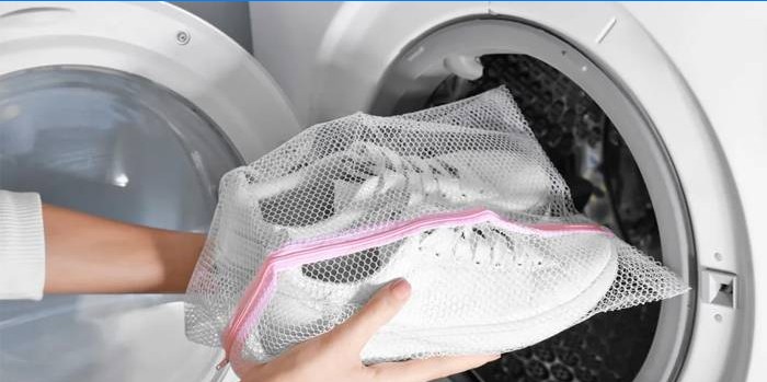 Vita sneakers i en påse för tvätt