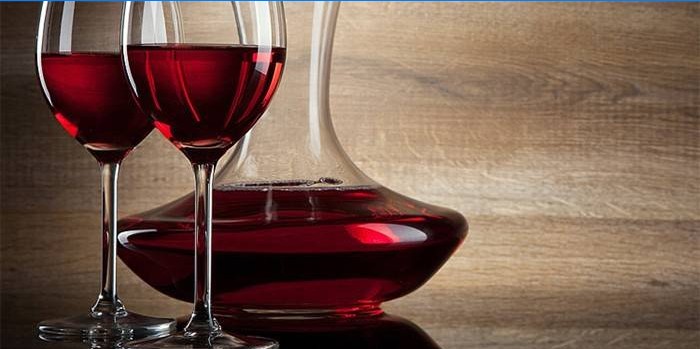 Två vinglas och en behållare med rött vin
