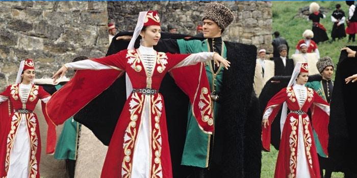 Kvinnor och män i tjetjenska kostymer dansar