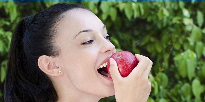 Flickan äter ett äpple