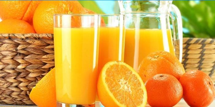 Apelsinjuice i en karaff och glas, citrusfrukter