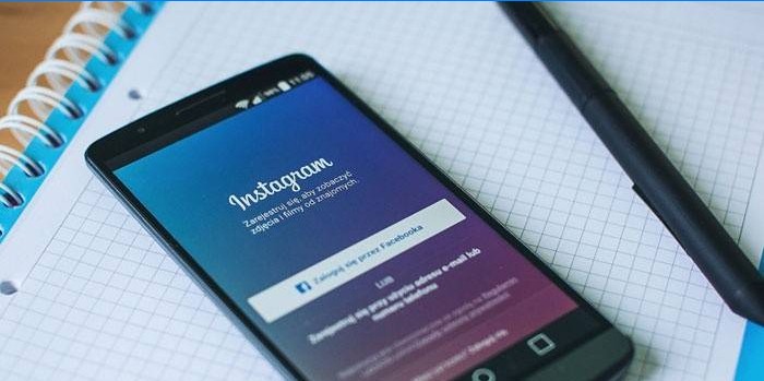 Instagram-applikation på telefon, anteckningsbok och penna
