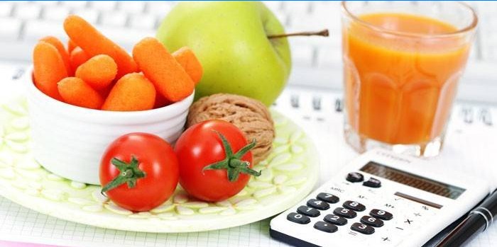 Frukter, grönsaker, ett glas juice och en miniräknare