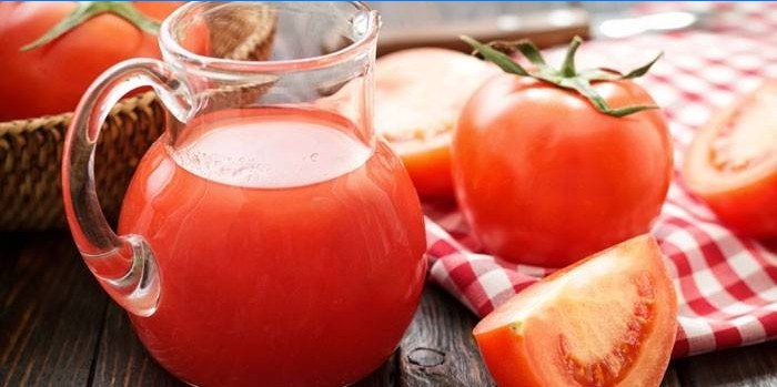 Tomatsaft i en kanna och tomat