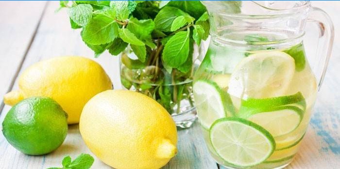 Sassi klart vatten med limefrukt och citron i en kanna