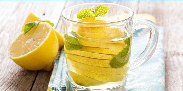 Vatten med citron och mynta i en kopp
