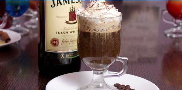 Irländskt kaffe med whisky och grädde i ett exponeringsglas