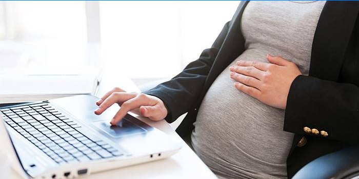 Gravid kvinna på en bärbar dator