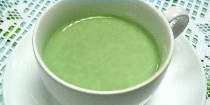 En kopp grönt te med ingefära och mjölk