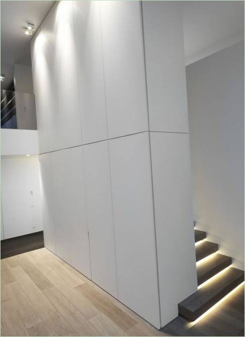 En hög vit pelare skiljer trappan från hallen i en herrgård i Brygge