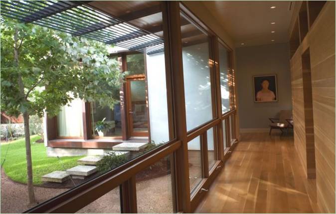 Glaserat galleri med utsikt över en innergård